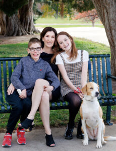 cropped photo of All for Kids Home Health founder with her daughter, son, and dog at the park
