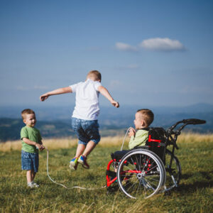 young boy in wheelchair plays jumprope with two other boys in open field All for Kids Home Health Colorado
